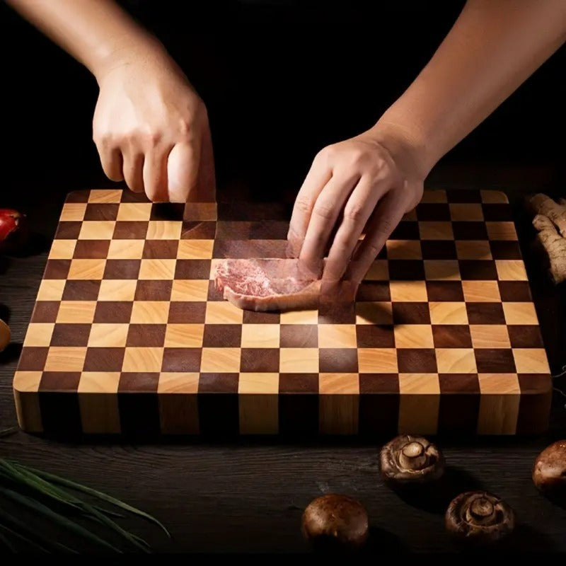 Person preparing food on a checkered wooden cutting board with ingredients around.