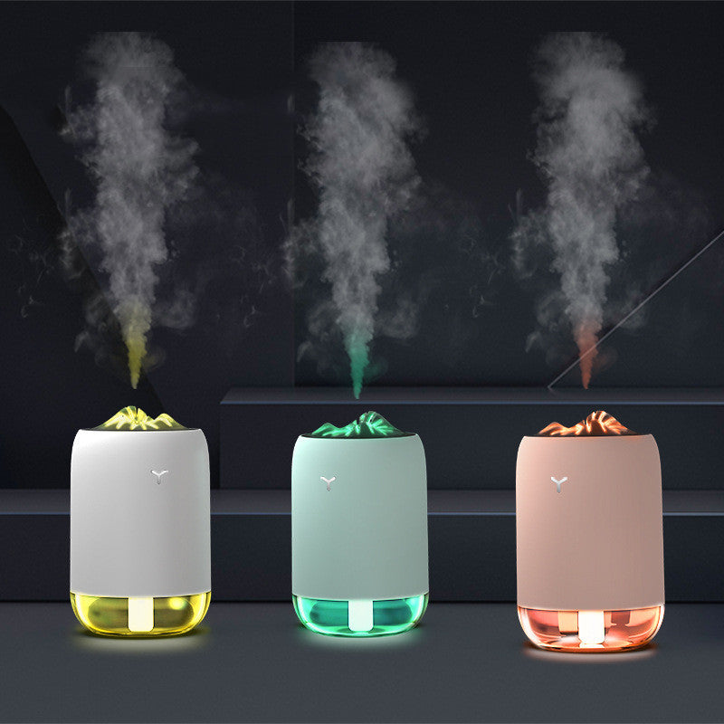 Three colorful humidifiers emitting mist against a dark background