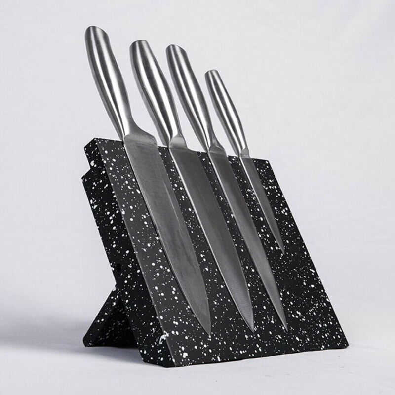 Set of four knives on a black speckled knife block against a white background