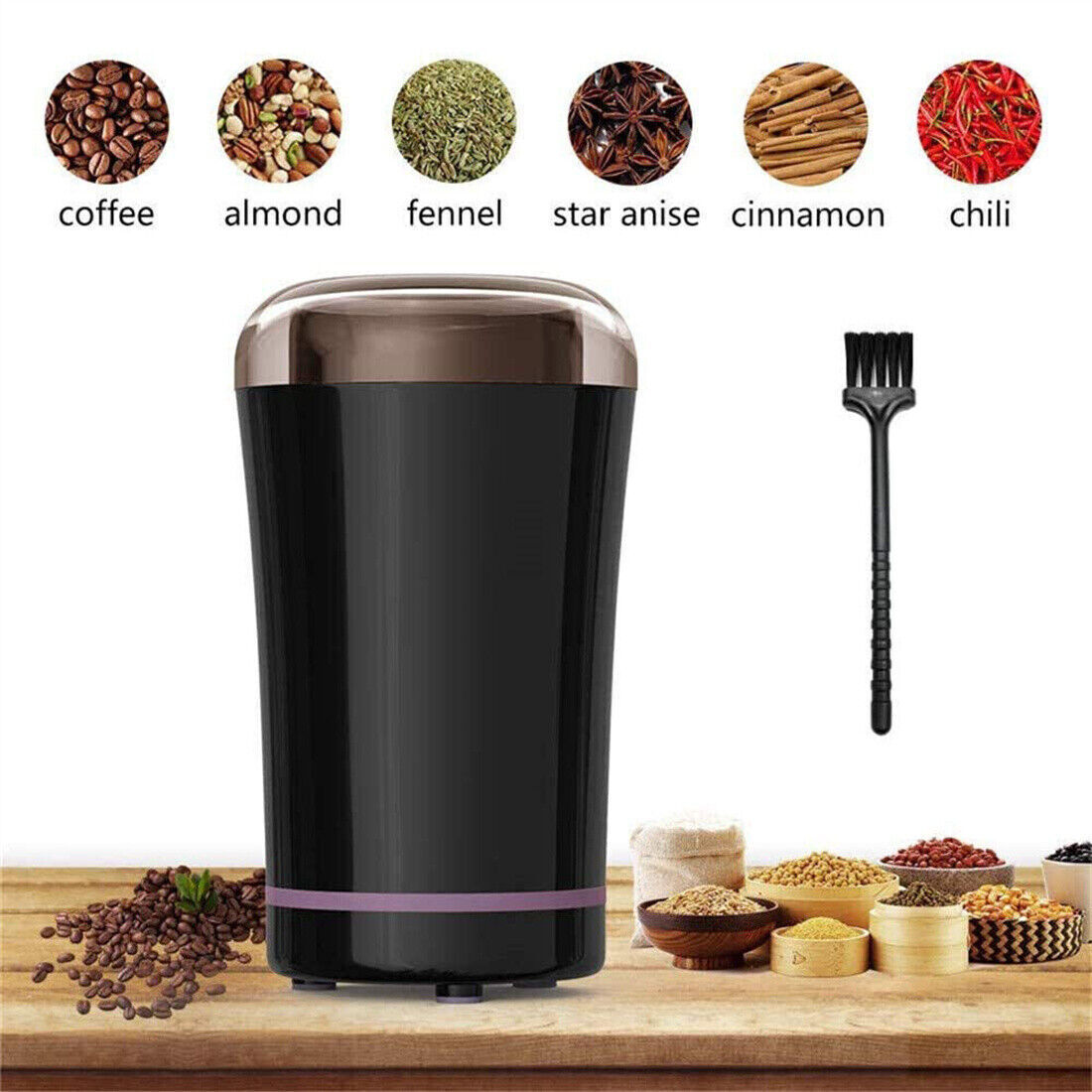 Black spice grinder with various spices and a brush on a wooden surface