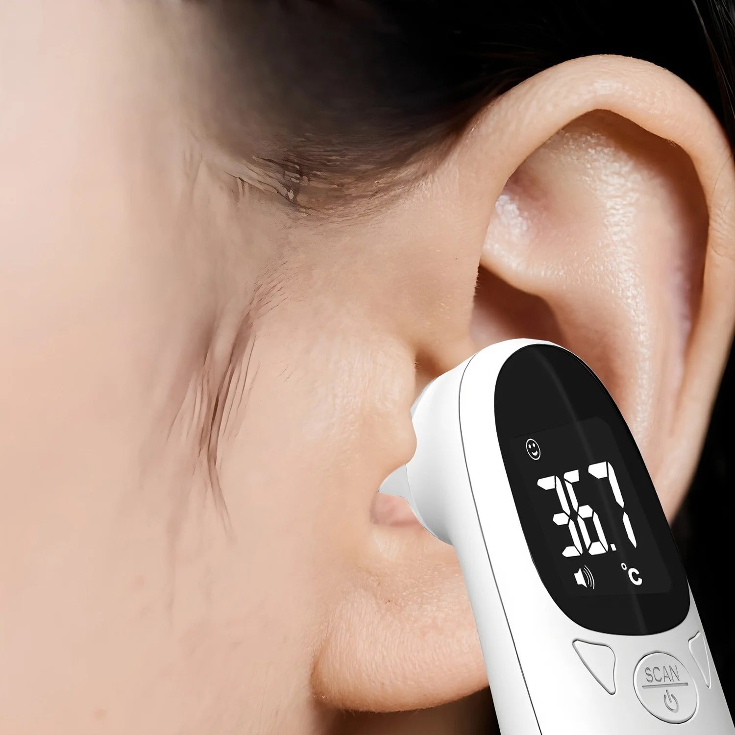 Digital thermometer being used to take a person's temperature with a close-up on the ear.