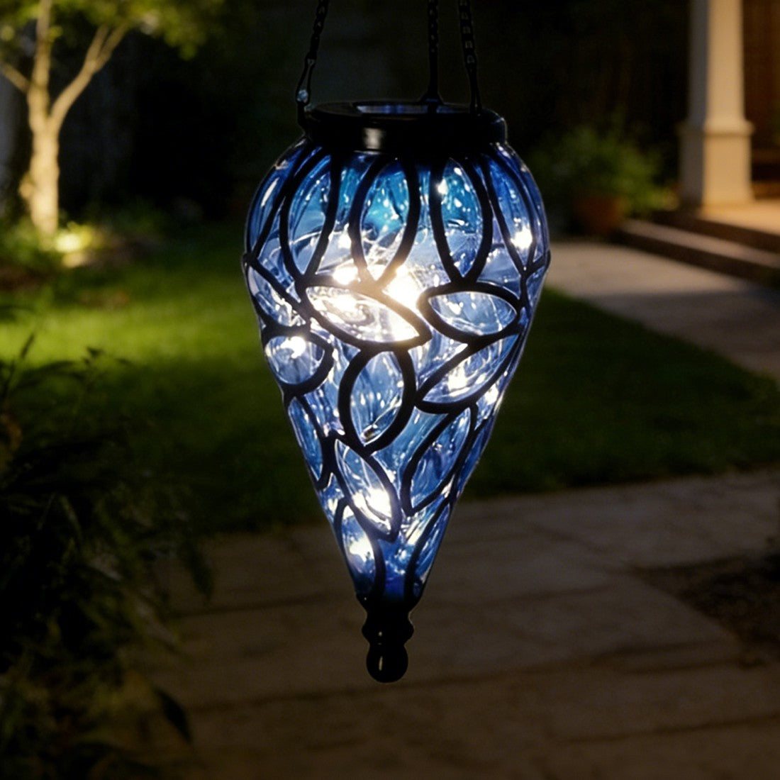 Decorative blue hanging lantern with intricate patterns, illuminated at night.