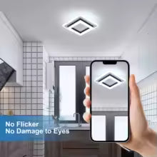 Hand holding a smartphone with a lighting app displayed, showing a bathroom interior.