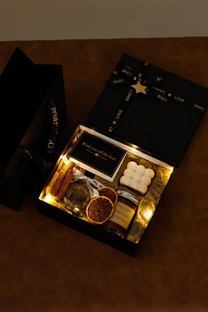 Glowing gift box with decorative items on a dark surface