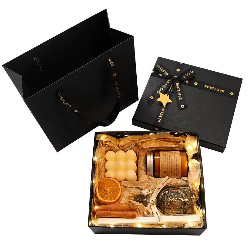 Gift set with candles, oranges, and other items in a black box labeled 'BESTLOVE'.