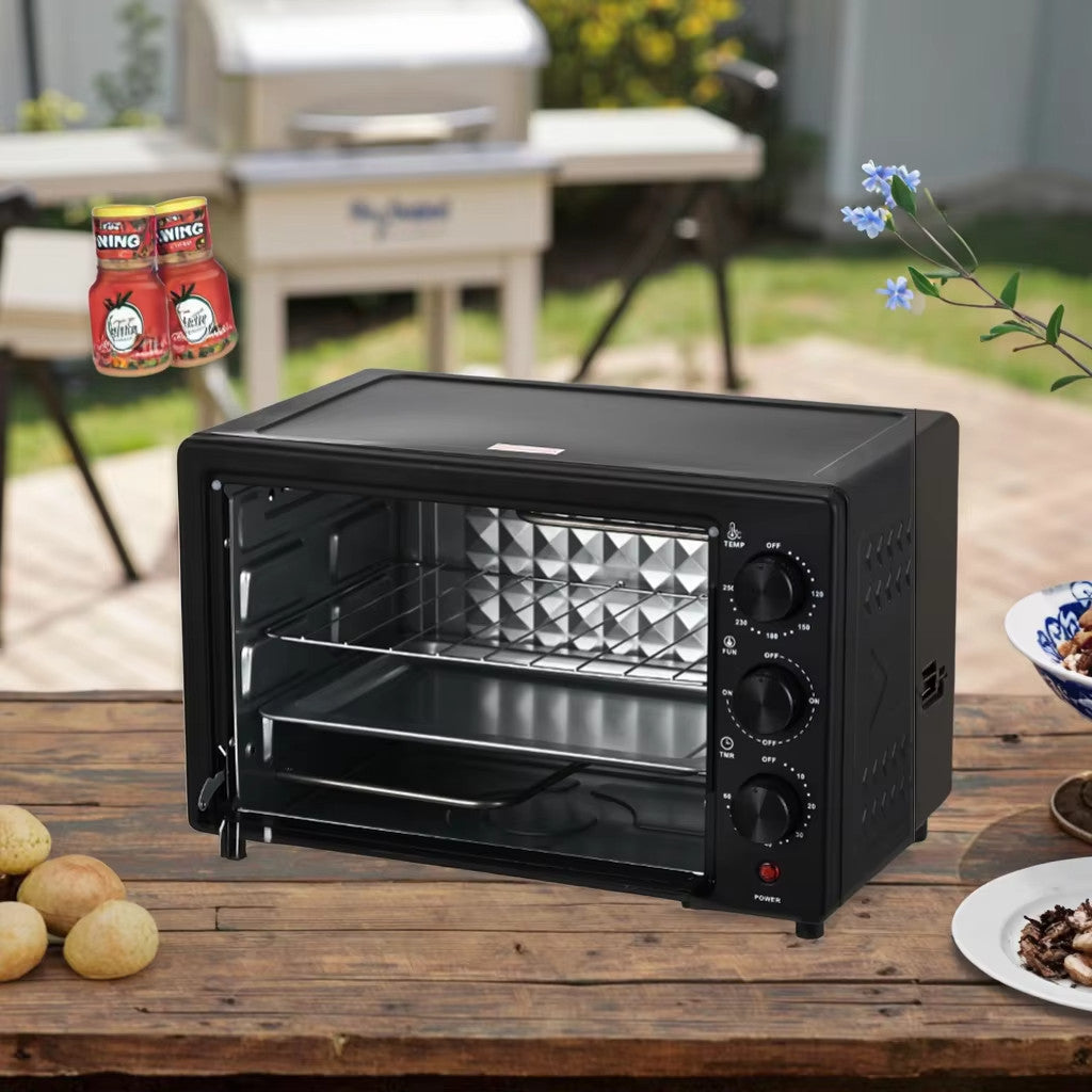 Black toaster oven on a wooden table outdoors with food items around