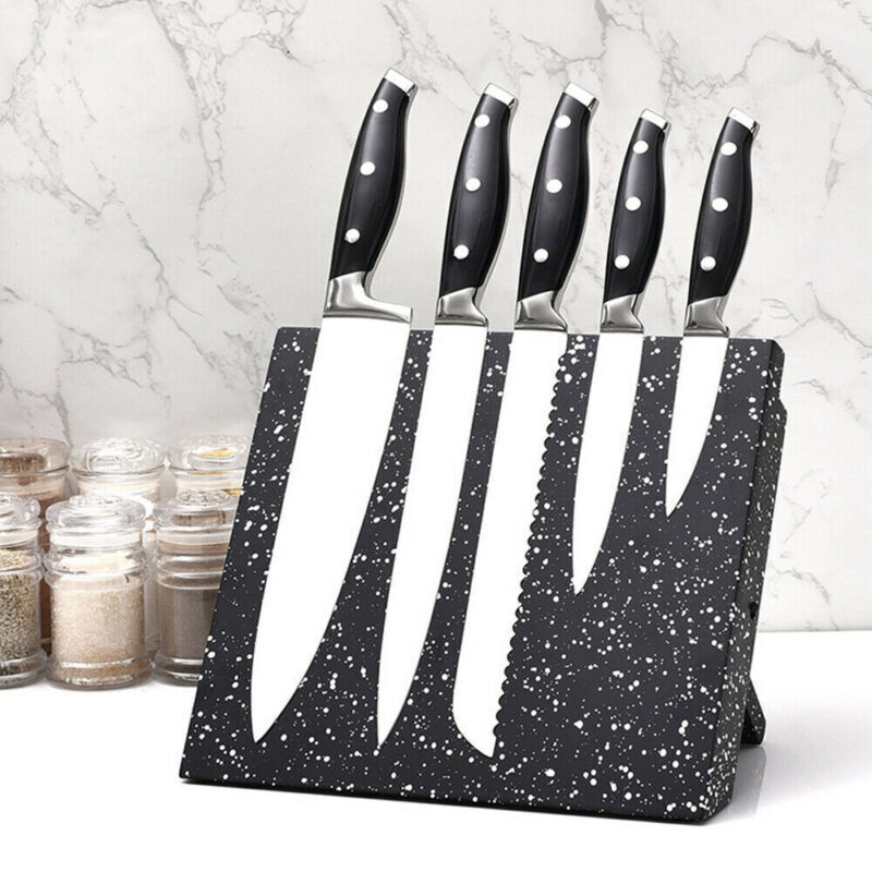 Set of knives on a speckled black and white knife block against a marble background