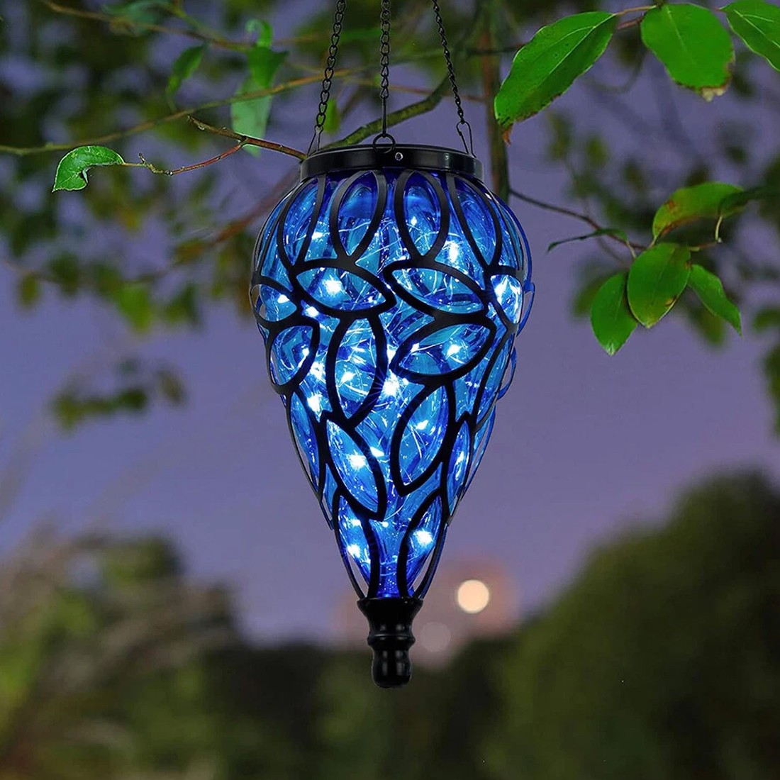 Blue LED hanging lantern with leaf patterns against a blurred natural background