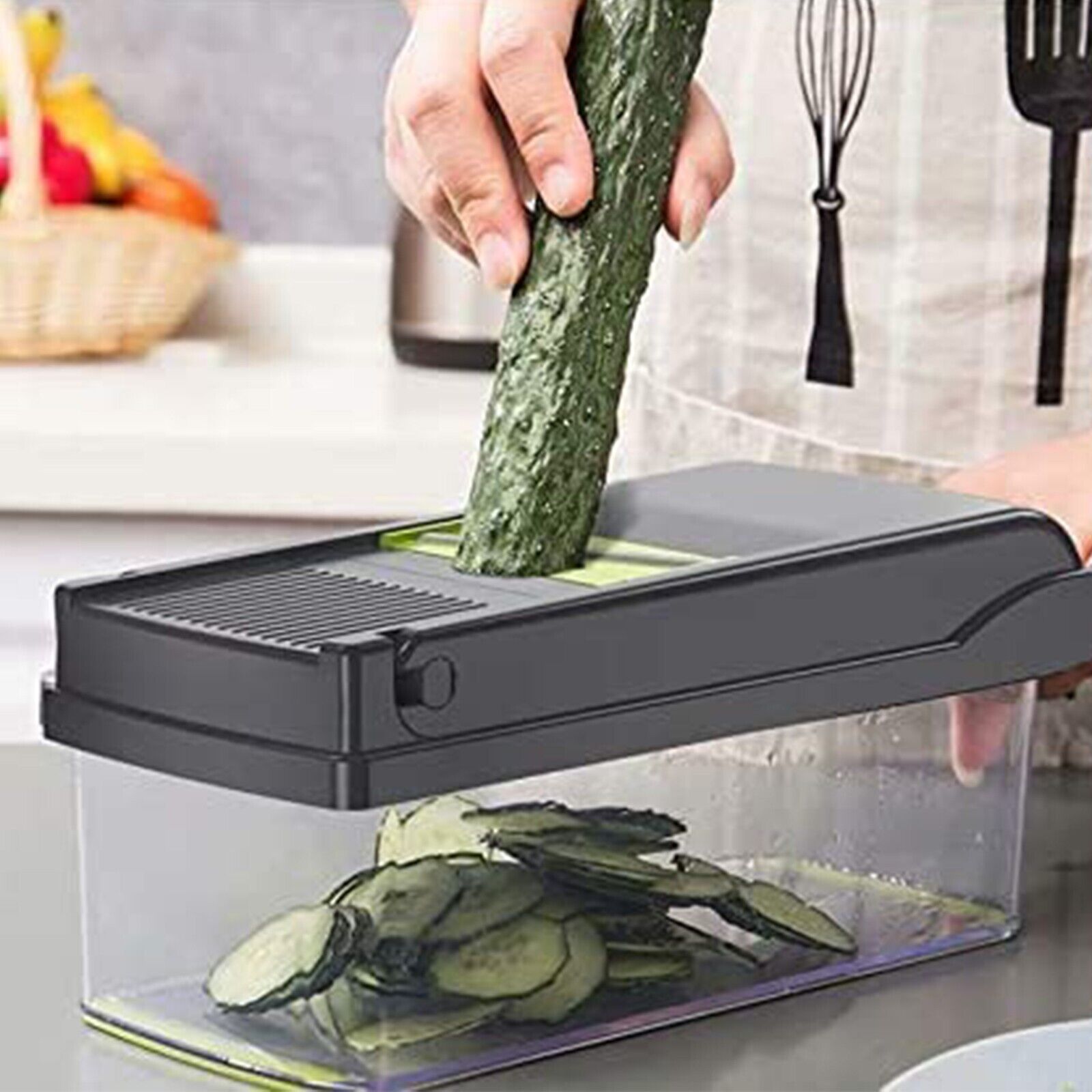 Person using a mandoline slicer to slice a cucumber in a kitchen setting.